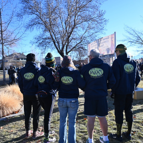 Max's staff standing facing away with sweatshirts that have their logo it